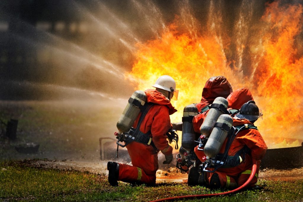Firefighter applying foam fire extinguishing agent